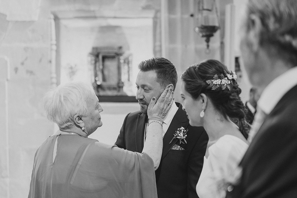 Tia del novio acaricia su cara en la boda