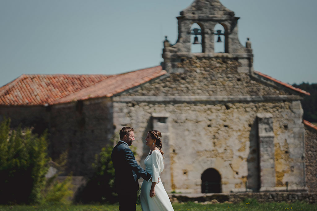 fotografía de Novios con iglesia de fondo en la boda