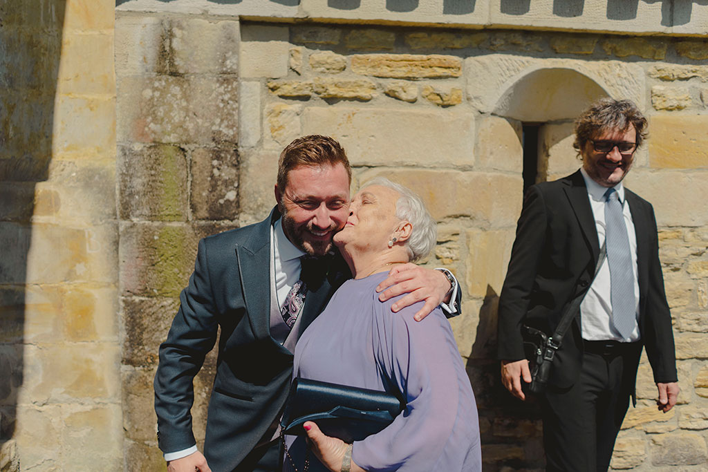 El novio recibe un beso de su tia en la boda