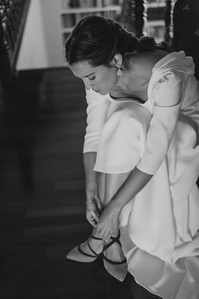 fotografía de la novia poniéndose los zapatos para su boda