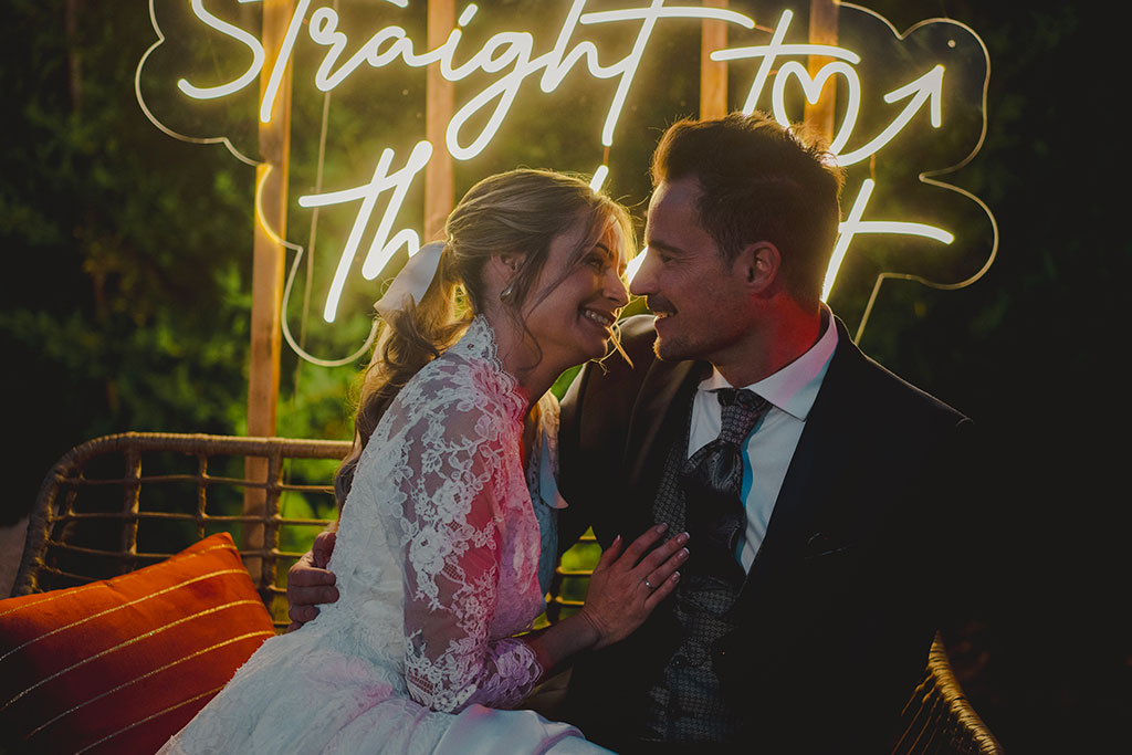 Novios bajo neon de su boda